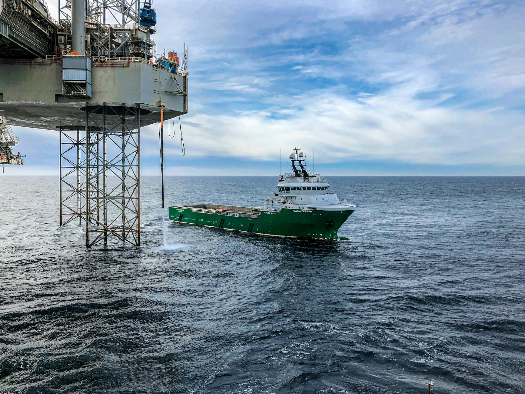 a green cargo ship on the sea